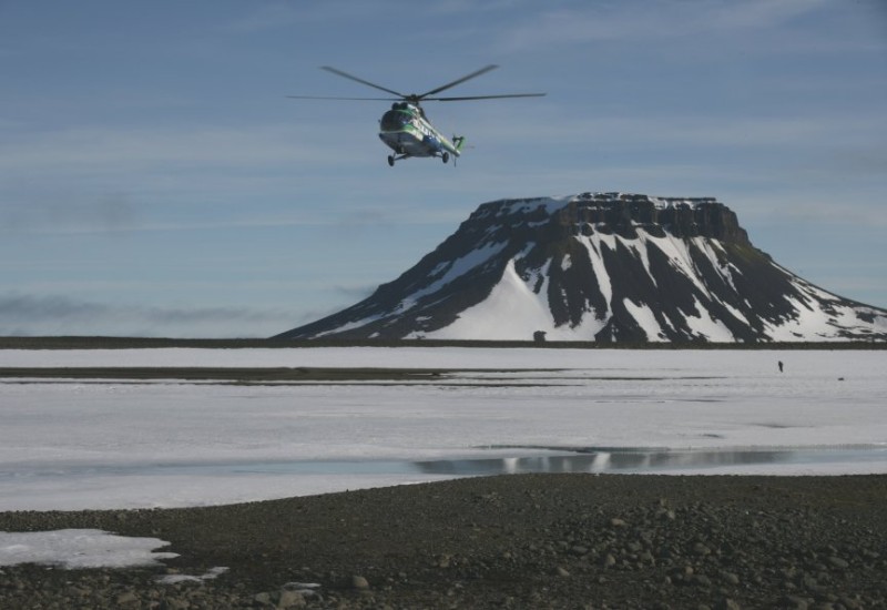 A helicopter flies above the North Pole