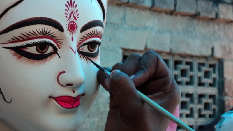 An artisan paints the eyes of Goddess Durga